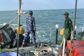 Tàu cứu nạn thuộc Bộ đội Biên phòng Kiên Giang lai dắt tàu gặp nạn trên biển về nơi an toàn. (Ảnh: TIẾN VINH)