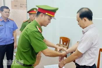 Công an tống đạt quyết định khởi tố vụ án, khởi tố bị can, ra lệnh bắt tạm giam 4 tháng đối với Hà Việt Hùng. (Ảnh: VĂN VŨ).