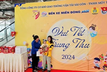 Hành khách có con nhỏ nhận quà Trung thu tại Bến xe Miền Đông mới (Thành phố Thủ Đức), Thành phố Hồ Chí Minh. (Ảnh: QUÝ HIỀN)