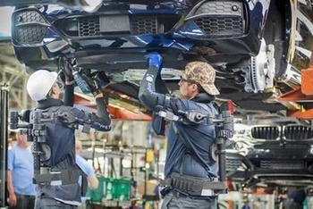Công nhân làm việc trên dây chuyền sản xuất xe ô-tô của hãng BMW (Đức). (Ảnh: DW/TTXVN)
