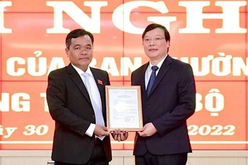 Bí thư Tỉnh ủy Hồ Văn Niên (bìa trái) trao Quyết định của Ban Thường vụ Tỉnh ủy cho đồng chí Trương Hải Long.