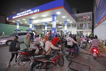 Người dân xếp hàng dài chờ mua xăng, dầu tại cửa hàng kinh doanh xăng, dầu trên phố Lạc Trung, tối 5/11. (Ảnh: TTXVN)