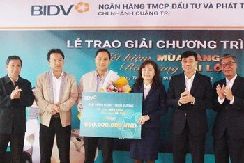 Lãnh đạo BIDV Chi nhánh Quảng Trị và lãnh đạo Ngân hàng Nhà nước Việt Nam Chi nhánh Quảng Trị trao giải thưởng cho khách hàng Lê Ngọc Phúc.