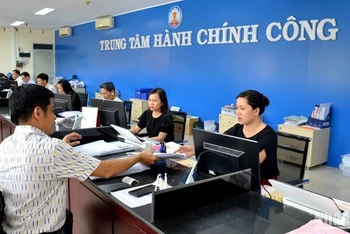 Công chức làm việc tại Trung tâm Hành chính công tỉnh Bình Thuận hướng dẫn và tiếp nhận hồ sơ của công dân, doanh nghiệp tại quầy giao dịch. (Ảnh: Đình Châu)