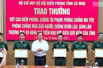 Chủ tịch Ủy ban nhân dân tỉnh Cà Mau Huỳnh Quốc Việt (áo trắng) tặng Bằng khen cho tập thể, cá nhân Biên phòng Cà Mau có thành tích tốt trong phá án về buôn lậu, ma túy.