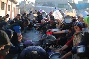 Người dân xếp hàng chờ được phát thức ăn cứu trợ tại Rafah, Dải Gaza, ngày 14/3/2024. Ảnh: THX/TTXVN