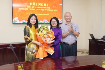 Hiệu trưởng Trường trung học cơ sở Giảng Võ 2 (ôm hoa) trong buổi nhận quyết định.