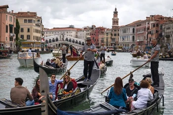 Du khách đi thuyền gondola tại Venice, Italy. (Ảnh: AFP/TTXVN)