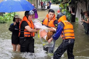 Lực lượng xung kích hỗ trợ di dời người dân khỏi vùng ngập lụt ở Nam Định.