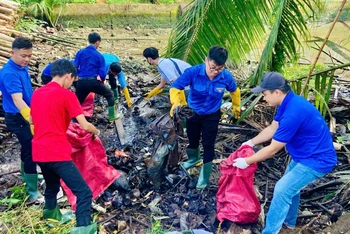 Lực lượng đoàn viên, thanh niên huyện Mỏ Cày Nam tích cực dọn dẹp vệ sinh môi trường. (Ảnh: HOÀNG TRUNG)