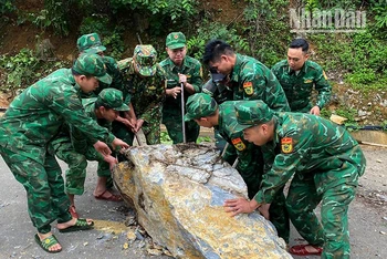 Cán bộ, chiến sĩ Đồn Biên phòng Chiềng Tương, Bộ đội Biên phòng tỉnh Sơn La khắc phục tuyến đường bị đá sạt lở chắn ngang.
