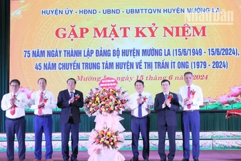 Đồng chí Lò Minh Hùng, Phó Bí thư Thường trực Tỉnh ủy Sơn La tặng hoa chúc mừng 75 năm ngày thành lập Đảng bộ huyện Mường La.