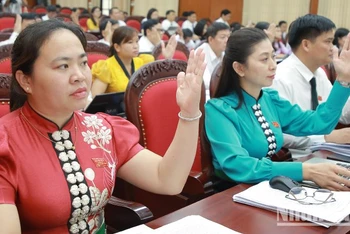 Các đại biểu Hội đồng nhân dân tỉnh Sơn La biểu quyết thông qua các dự thảo nghị quyết tại Kỳ họp thứ 9.