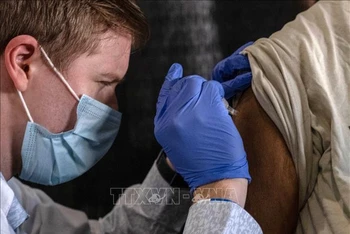 Nhân viên y tế tiêm vaccine ngừa Covid-19 cho người dân tại Detroit, Michigan, Mỹ. (Ảnh: AFP/TTXVN)