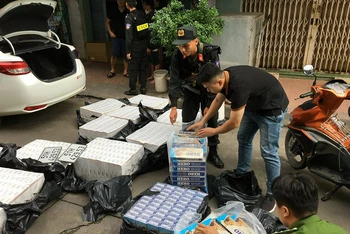 Lực lượng Công an tạm giữ số thuốc lá lậu tại tiệm tạp hóa Ngọc Hằng.