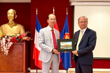 Ông Hoàng Việt Trung, Giám đốc Trung tâm Bảo tồn Di tích Cố đô Huế, trao tặng quà lưu niệm tới Đại sứ Việt Nam tại Pháp Đinh Toàn Thắng. (Ảnh: MINH DUY)
