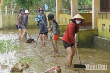 Giáo viên các trường học ở huyện Lệ Thủy dọn bùn, vệ sinh trường lớp để học sinh đi học trở lại.