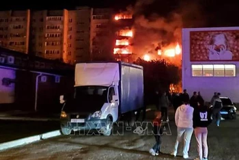 Khói lửa bốc lên từ tòa nhà sau khi một máy bay được cho là quân sự rơi xuống khu dân cư ở thành phố Yeysk, vùng Krasnodar, Tây Nam Nga tối 17/10/2022. (Ảnh: AFP/TTXVN)