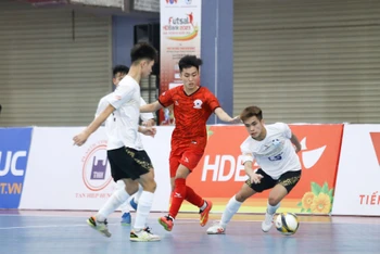 Tình huống bóng giữa cầu thủ đội Tân Hiệp Hưng (áo đỏ) và Hà Nội (áo trắng) trong trận đấu tại Nhà thi đấu quận 8, Thành phố Hồ Chí Minh.
