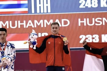 Lại Gia Thành (giữa) giành Huy chương Vàng ở hạng cân 55kg nam. (Ảnh: TTXVN)