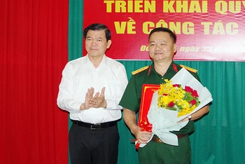 Đồng chí Nguyễn Hồng Lĩnh, Ủy viên Trung ương Đảng, Bí thư Tỉnh ủy, Bí thư Đảng ủy Quân sự tỉnh Đồng Nai trao quyết định và tặng hoa chúc mừng Đại tá Bùi Đăng Ninh.