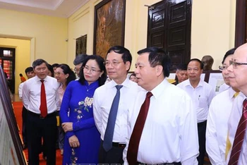 Đồng chí Nguyễn Xuân Thắng và các đại biểu tham quan triển lãm. (Ảnh: TTXVN)