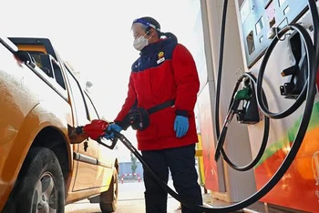 Bơm xăng cho các phương tiện tại một cây xăng ở tỉnh Giang Tô, Trung Quốc. (Ảnh: AFP/TTXVN)