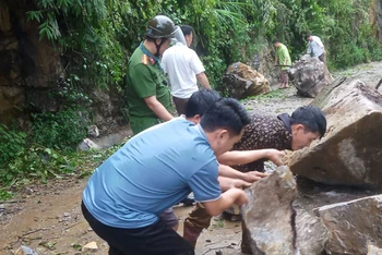 Lực lượng chức năng dọn dẹp đất, đá sạt lở trên tuyến đường nối từ xã Pà Cò đi xã Hang Kia, khu vực xóm Pà Cò Lớn, xã Pà Cò, Mai Châu. (Ảnh: Báo Hòa Bình) 