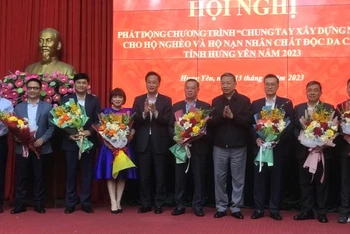 Bộ trưởng Công an Tô Lâm tặng hoa cho đại diện các tổ chức kinh tế, doanh nghiệp đã tài trợ xây nhà ở cho hộ nghèo, hộ nạn nhân chất độc da cam ở tỉnh Hưng Yên.