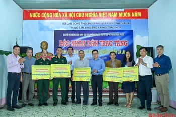 Tổng Biên tập Báo Nhân Dân Lê Quốc Minh cùng các đại biểu và nhà tài trợ trao tặng bàn bóng bàn cho các đơn vị. 