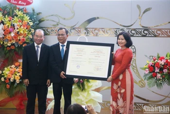 Phó Giáo sư, Tiến sĩ Lê Ngọc Quỳnh Lam (bên phải) trao Giấy chứng nhận kiểm định chất lượng giáo dục cho lãnh đạo Trường đại học Thủ Dầu Một. 