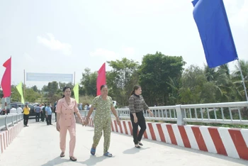 Người dân lần đầu tiên đi qua cầu giao thông nông thôn vừa xây dựng tại huyện Vĩnh Hưng, tỉnh Long An.