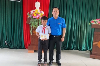 Anh Đỗ Duy Nam trao huy hiệu "Tuổi trẻ dũng cảm" cho em Kpă Nguyên. 