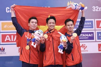 3 nam vận động viên đội tuyển karate Việt Nam (Phạm Minh Đức, Giang Việt Anh, Lê Hồng Phúc) vui mừng với tấm Huy chương Vàng nội dung kata đồng đội nam. (Ảnh: TTXVN)