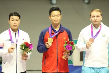 Vận động viên Phạm Quang Huy trên bục nhận Huy chương cùng hai đối thủ Hàn Quốc và Uzbekistan. (Ảnh: Đoàn Thể thao Việt Nam)