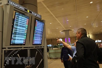 Hành khách theo dõi danh sách các chuyến bay bị hủy trên bảng thông báo tại Sân bay Quốc tế Ben Gurion ở Tel Aviv, Israel ngày 7/10. (Ảnh: AFP/TTXVN)
