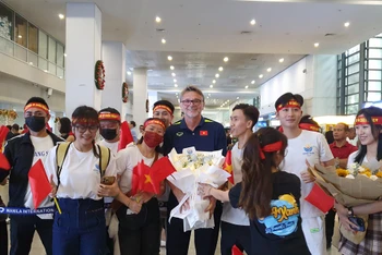 Cổ động viên Việt Nam tại Philippines tặng hoa chào mừng huấn luyện viên Philippe Troussier và đội tuyển tại sân bay Ninoy Aquino. (Ảnh: VFF)
