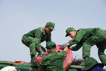 Chiến sĩ Bộ đội Biên phòng tỉnh Tiền Giang vận chuyển rác đưa đi xử lý. 