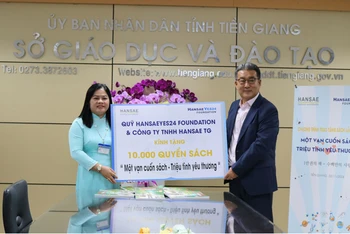 Ông Shin Soo-chul, Chủ tịch Công ty Hansae Việt Nam trao bảng tượng trưng cho đại diện ngành giáo dục và đào tạo tỉnh Tiền Giang.