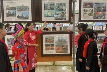 Giới thiệu cho học sinh dân tộc về hình ảnh tại triển lãm.