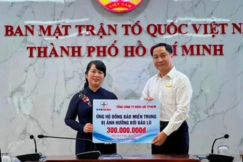 Đại diện Tổng Công ty Điện lực Thành phố Hồ Chí Minh trao 300 triệu đồng ủng hộ đồng bào miền trung gặp khó khăn do cơn bão số 4 gây ra.