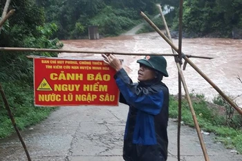 Bộ đội biên phòng đặt biển cảnh báo khu vực ngập sâu nguy hiểm ở vùng miền núi huyện Minh Hóa.