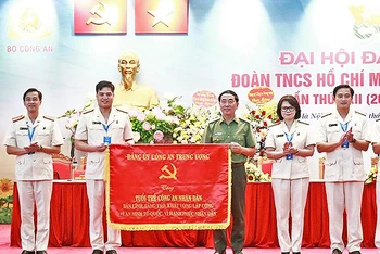 Thượng tướng Trần Quốc Tỏ (áo xanh) thay mặt Đảng ủy Công an nhân dân trao bức trướng “Bản lĩnh, sáng tạo, khát vọng lập công vì an ninh Tổ quốc, vì hạnh phúc nhân dân” tặng tuổi trẻ Công an nhân dân. 