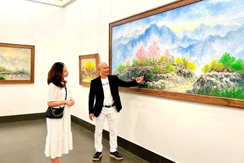 Họa sĩ Nguyễn Minh Sơn giới thiệu tác phẩm của mình tới khách tham quan.