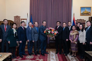 Đại sứ Đặng Minh Khôi tặng hoa đại diện Đại sứ quán Lào. (Ảnh: THANH THỂ)