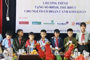 Phó Tổng Giám đốc Bảo hiểm xã hội Việt Nam Nguyễn Đức Hòa trao tặng thẻ Bảo hiểm y tế cho học sinh nghèo xã Quảng Đông.