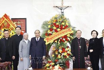Chủ tịch nước Nguyễn Xuân Phúc tặng hoa chúc mừng Tòa Tổng Giám mục Hà Nội Tổng giáo phận Hà Nội. (Ảnh: Thống Nhất/TTXVN)