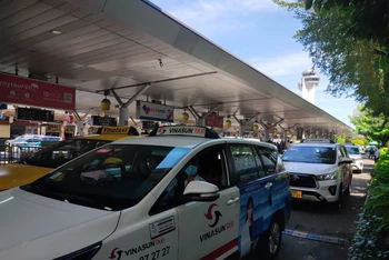 Các hãng taxi đón khách tại làn C sân bay Tân Sơn Nhất. (Ảnh: THẾ ANH)