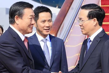 Bộ trưởng Nhà ở và Xây dựng đô thị, nông thôn Trung Quốc Nghê Hồng đón Chủ tịch nước Võ Văn Thưởng tại Sân bay Bắc Kinh. (Ảnh: TTXVN)