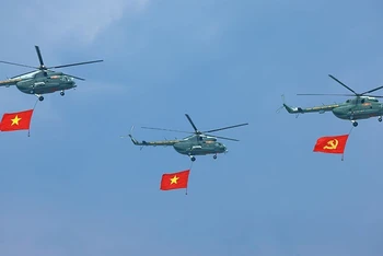 Phần trình diễn của trực thăng mang cờ Đảng, cờ Tổ quốc tại Lễ kỷ niệm 70 năm Chiến thắng Điện Biên Phủ. (Ảnh: TTXVN)